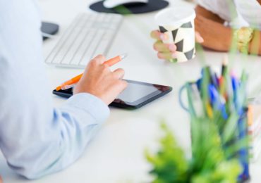 Portrait of two business woman working in office with digital tablet.